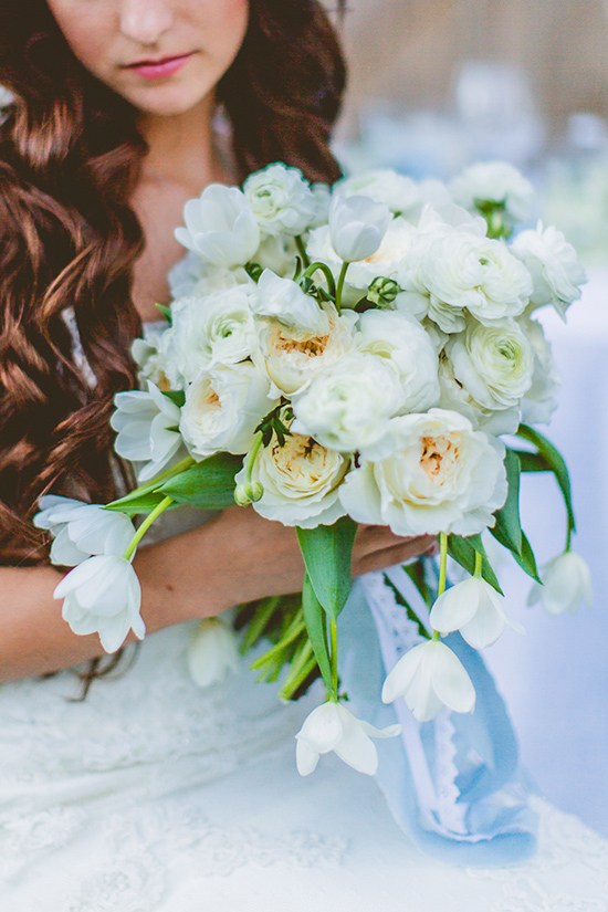 Bride holding white bridal bouquet of tulips and roses