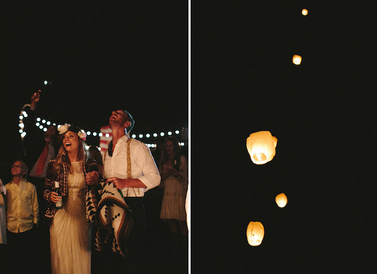 Couple watching lanterns rise into the night sky at a wedding
