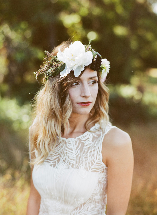 Woman in white dress and floral crown looking away