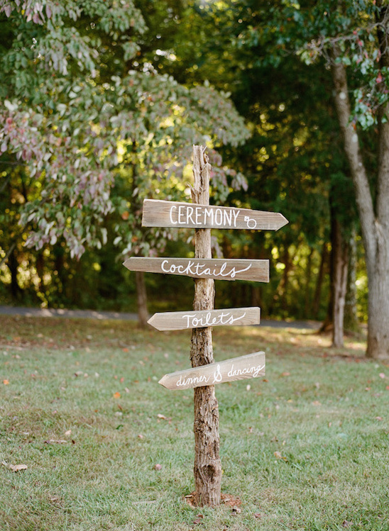 Rustic wooden wedding direction sign in outdoor setting