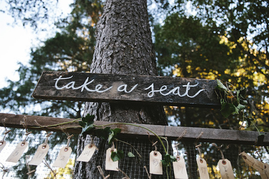 Wooden sign Take a Seat at a rustic wedding ceremony