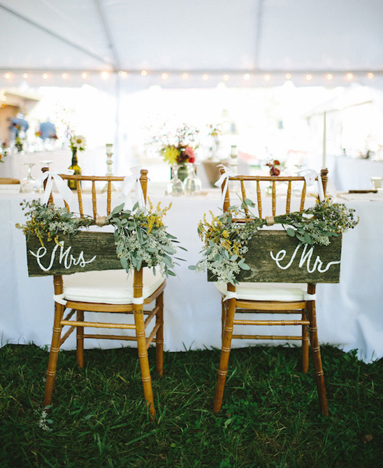 Wedding chairs with Mr and Mrs signs and floral decorations