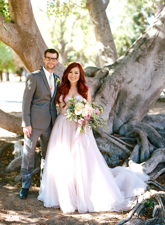 Happy couple on their wedding day under a large tree