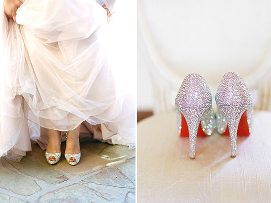 Sparkling bridal shoes peek out from under a wedding dress