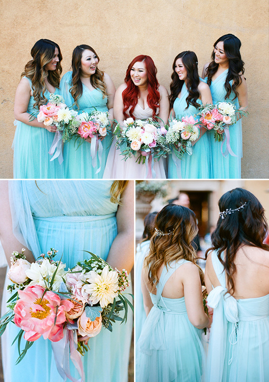 Bridesmaids in light blue dresses with bouquets, smiling at wedding