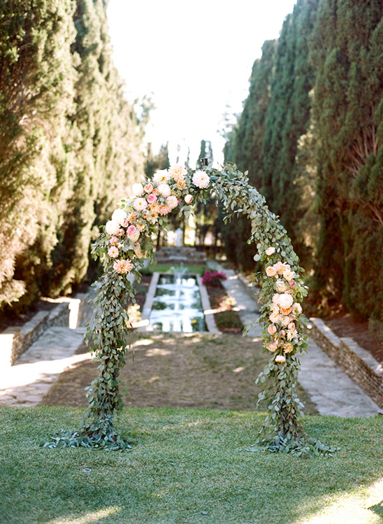 Floral archway decorates a garden for a wedding ceremony