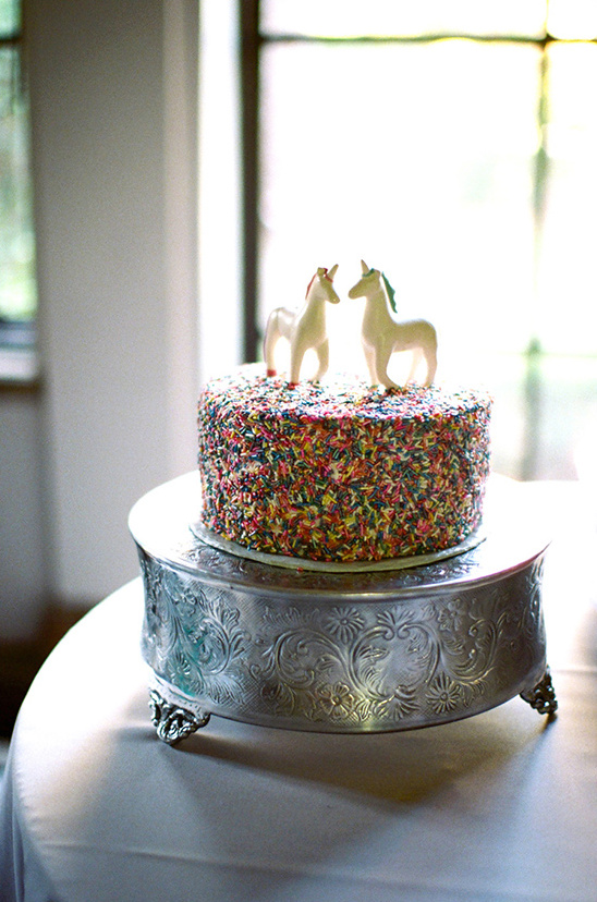 Unicorn cake with sprinkles on a vintage silver cake stand