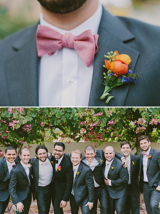 Groomsmen in suits with pink bow tie and boutonniere