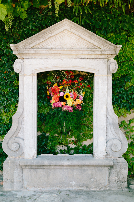 Stone frame with vibrant flowers and green foliage background