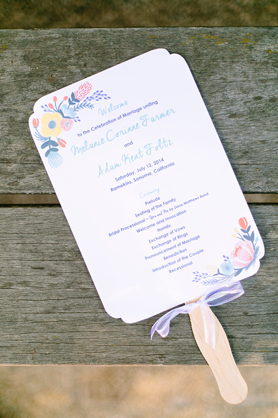 Wedding ceremony fan with floral decorations on wooden surface