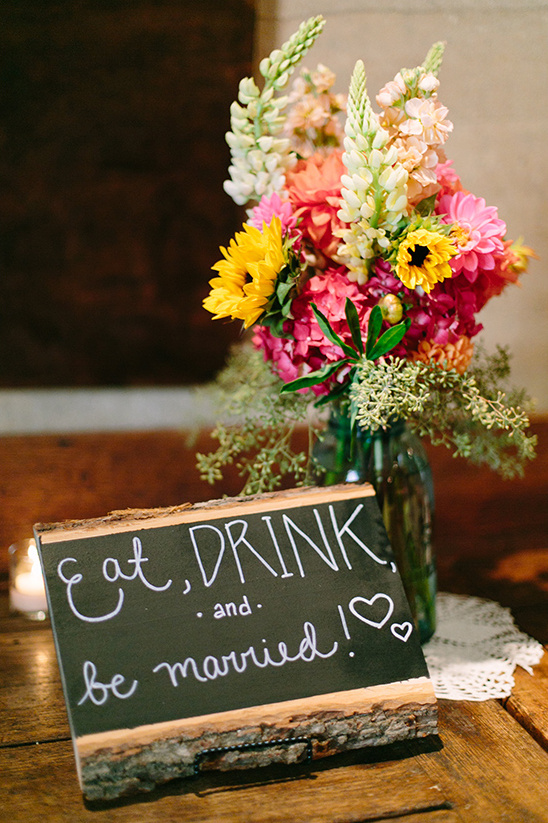 Wedding sign with colorful flowers and a eat, drink, be married message