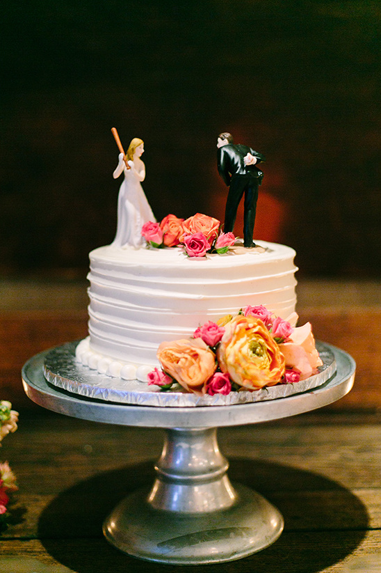 Funny wedding cake topper with bride holding a baseball bat