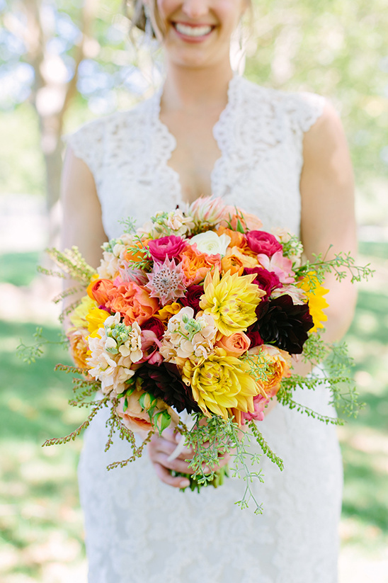 Bride with colorful wedding bouquet, smiling happily