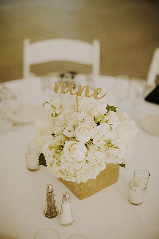 Elegant wedding table centerpiece with white flowers and nine sign