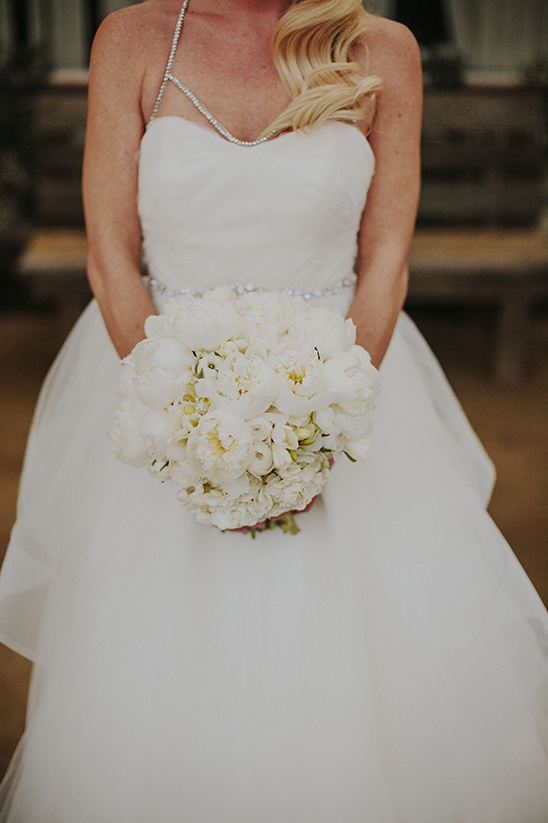 Bride holding a white flower bouquet in a wedding dress