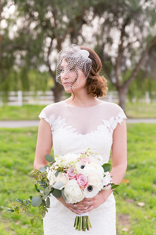 Elegant bride in a white dress holding a bouquet with a veil