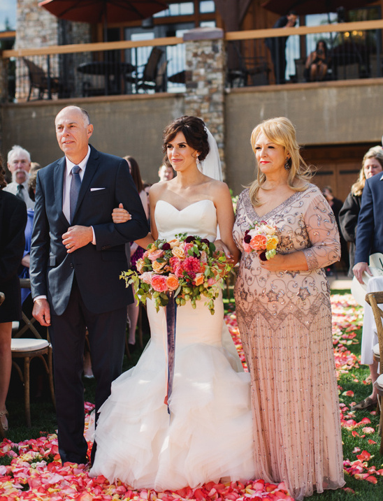 Bride walking down the aisle with parents at a wedding ceremony