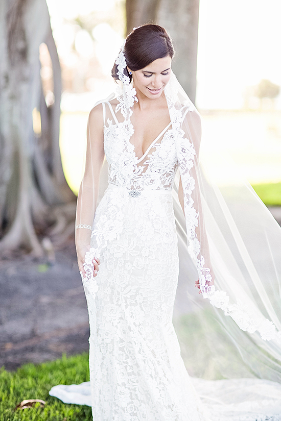 Elegant bride in a lace wedding dress, veil flowing in the wind