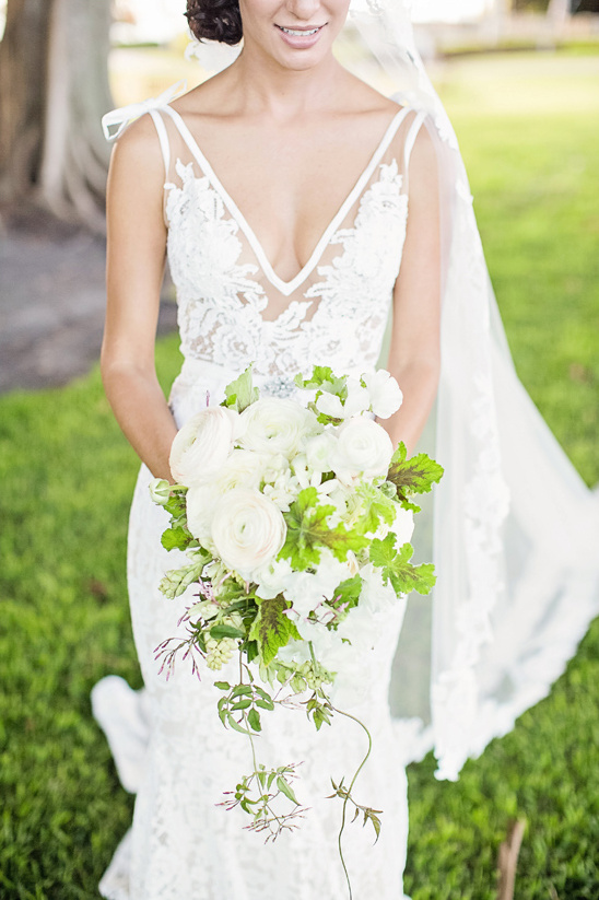 Bride in a beautiful wedding dress holding a white floral bouquet