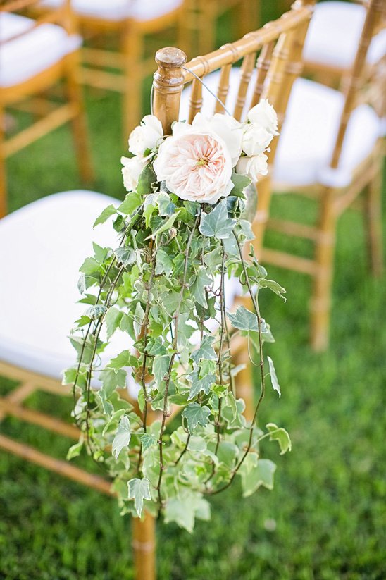 Wedding chair decorated with flowers and lush green ivy