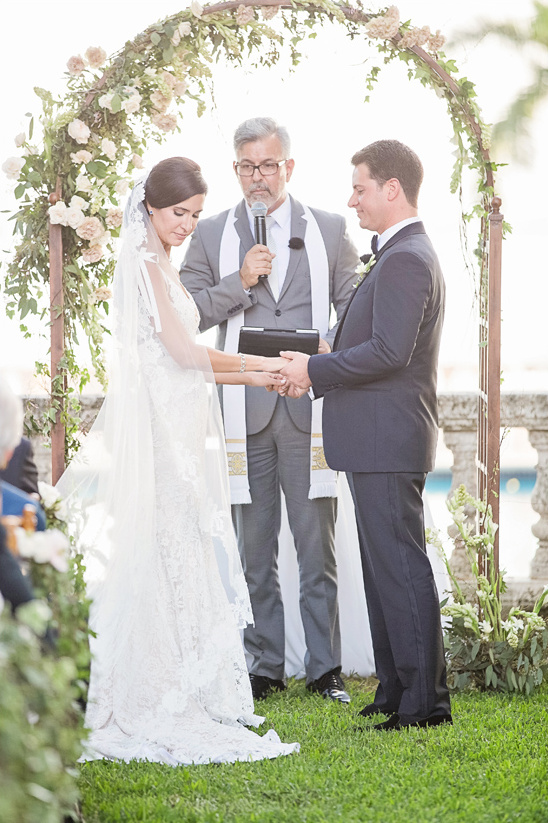 Bride and groom holding hands at outdoor wedding ceremony