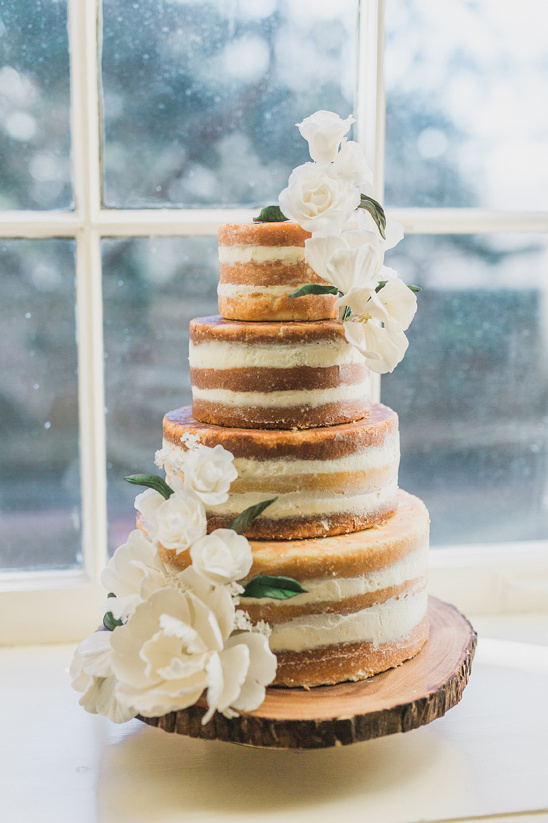 Naked wedding cake with white flowers and white frosting @weddingchicks
