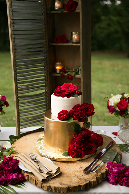 Elegant wedding cake decorated with red roses on wood slice