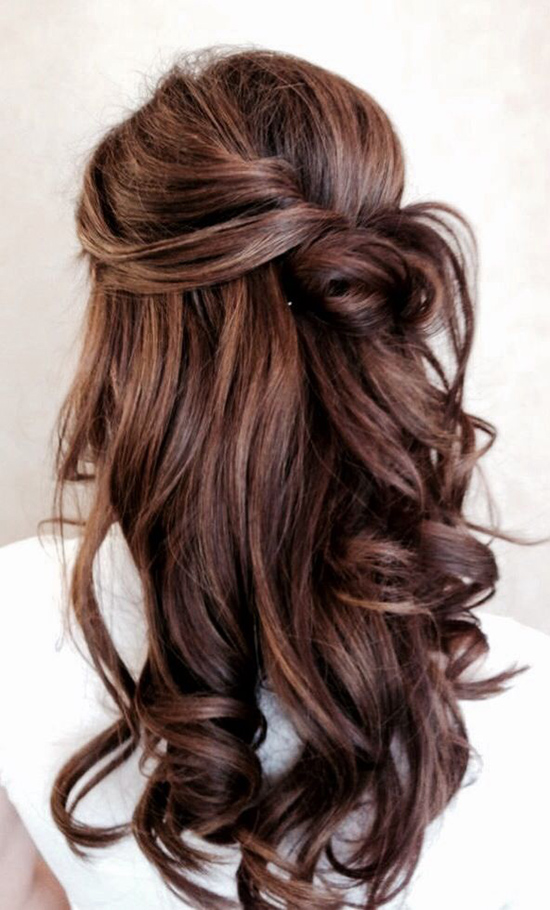 Elegant half updo hairstyle with voluminous brown curls