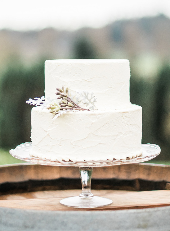 Elegant two tier white wedding cake on glass stand