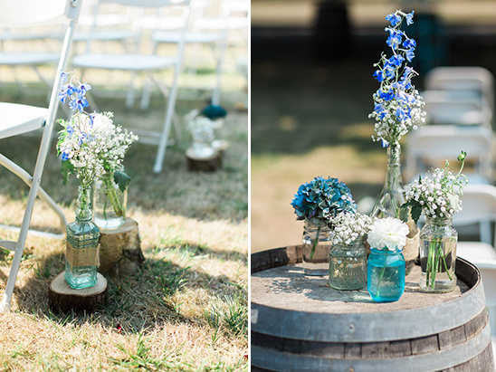 Wedding decor with blue and white flowers in glass jars and bottles