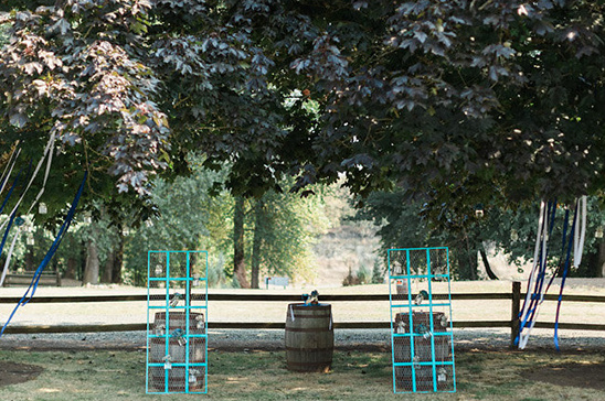 Wedding ceremony setup with barrels, teal frames and nature backdrop