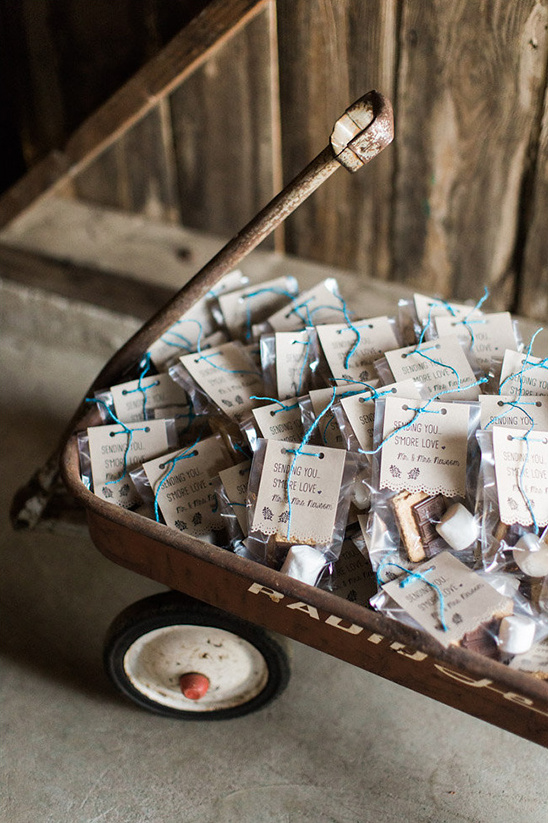 Old red wagon filled with s'mores favors, rustic wedding treat