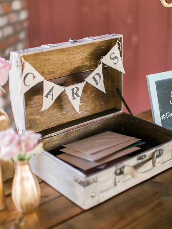 Vintage suitcase used as a wedding card box with banner reading CARDS