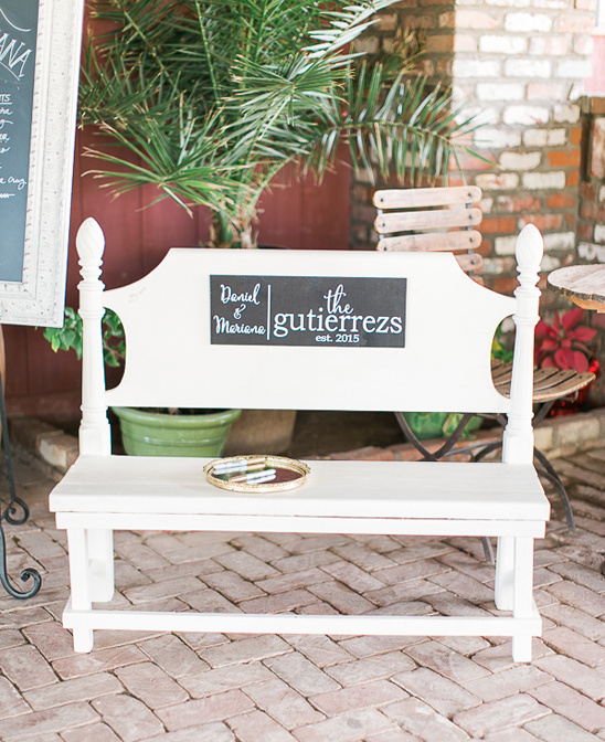 White bench with family name sign for wedding guests