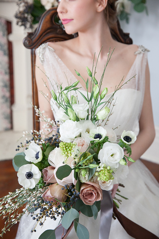 Bride in dress holding a beautiful wedding bouquet of white flowers