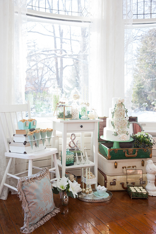 Elegant wedding cake display with vintage suitcases and decor