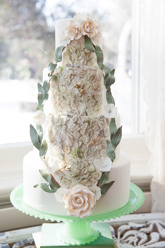 Elegant wedding cake with floral details and green accents