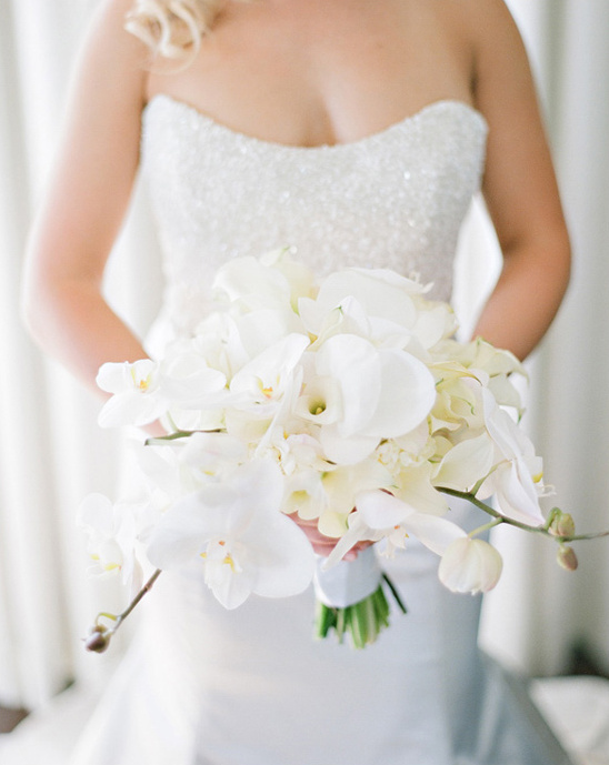 Bride holding a beautiful white orchid wedding bouquet