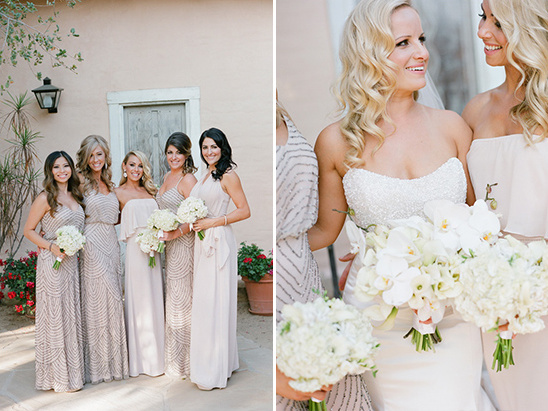 Bridesmaids in elegant dresses holding white bouquets at a wedding