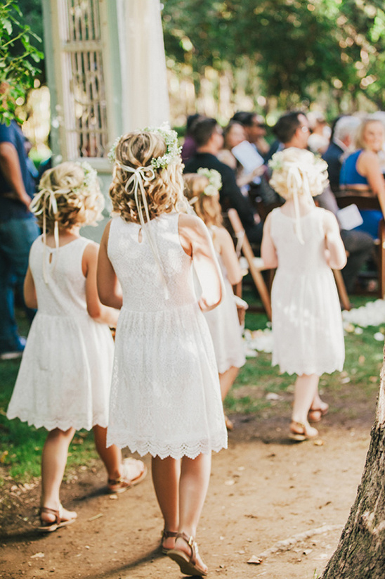 Flower girls walking down the aisle at an outdoor wedding