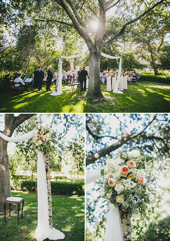 Outdoor wedding ceremony under a tree with floral decorations