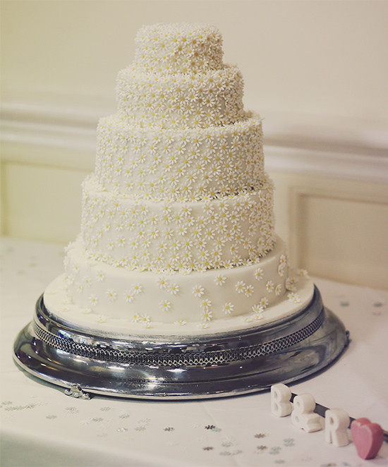 Elegant white wedding cake decorated with daisy flowers