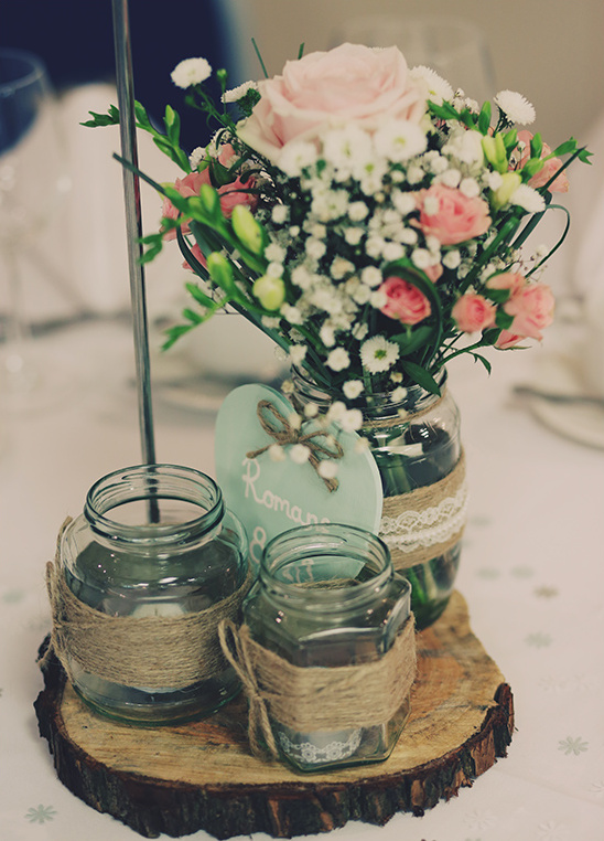 Rustic wedding centerpiece with flowers and decorated jars