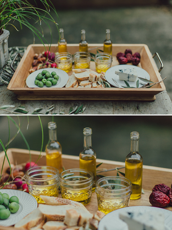 Appetizers on a tray olive oil cheese bread and olives