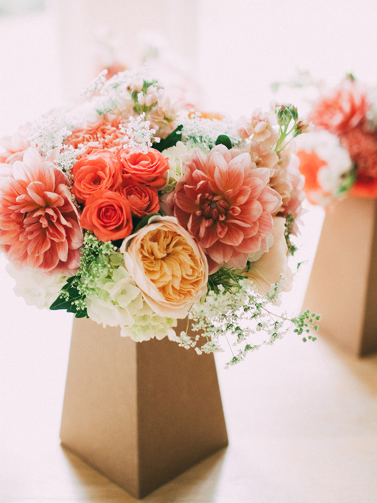 Bouquet of coral and peach flowers in modern geometric vases