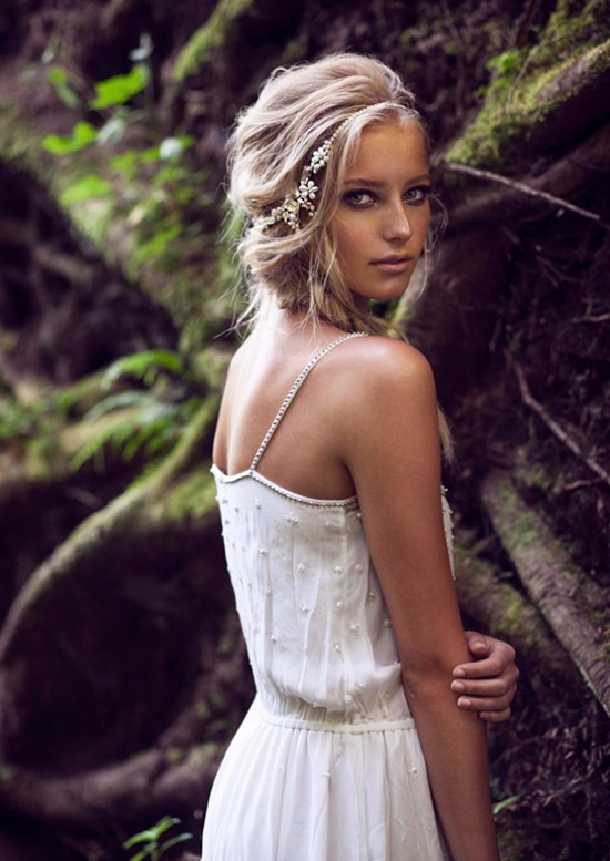 Beautiful woman in a white dress with floral hair piece in the woods