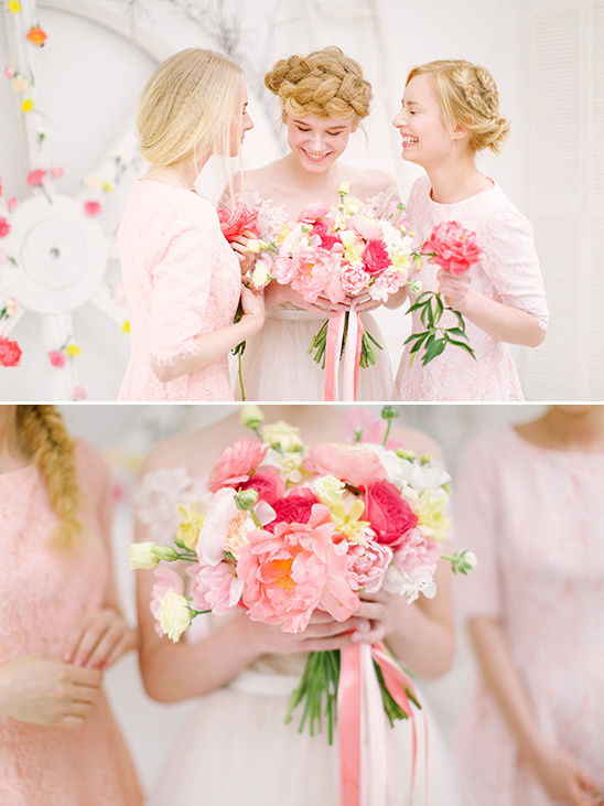 Bridesmaids admire a pink floral bouquet at a wedding