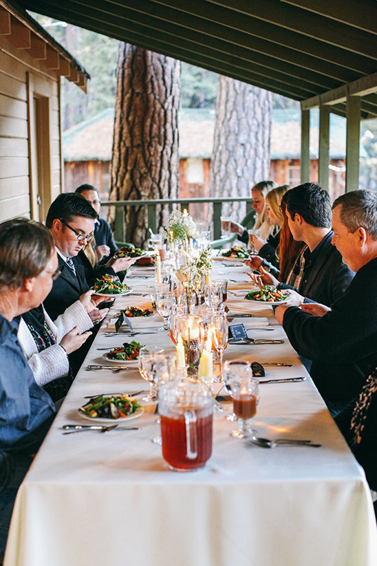 Guests enjoying a meal at an outdoor dinner party,  long table setting