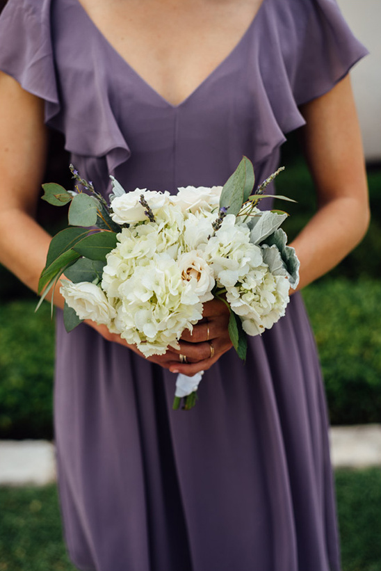 Woman in a purple dress holding a white flower bouquet
