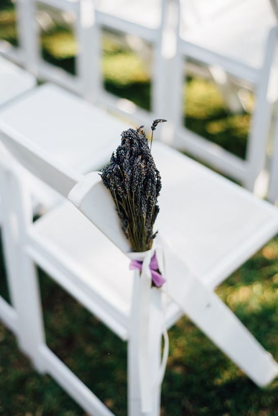 Bouquet of lavender tied to a chair with ribbons on wedding day